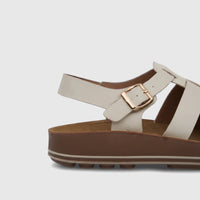 White PC Ladies Comfort Sandal with a platform sole and gold buckle, shown in a side view.