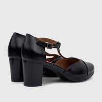 Black ladies dress shoes with block heels and a T-bar strap, made of leather-like material, viewed from the side and back.