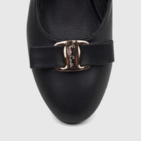 Close-up of a black ladies' dress court shoe featuring a decorative gold buckle with subtle engraving, positioned against a