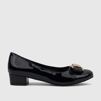 Black patent leather ladies dress court shoe with a low block heel and decorative gold-tone buckle, viewed from the side.