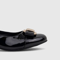 Close-up of a shiny black patent leather ladies dress court shoe with an elegant golden buckle on the vamp.