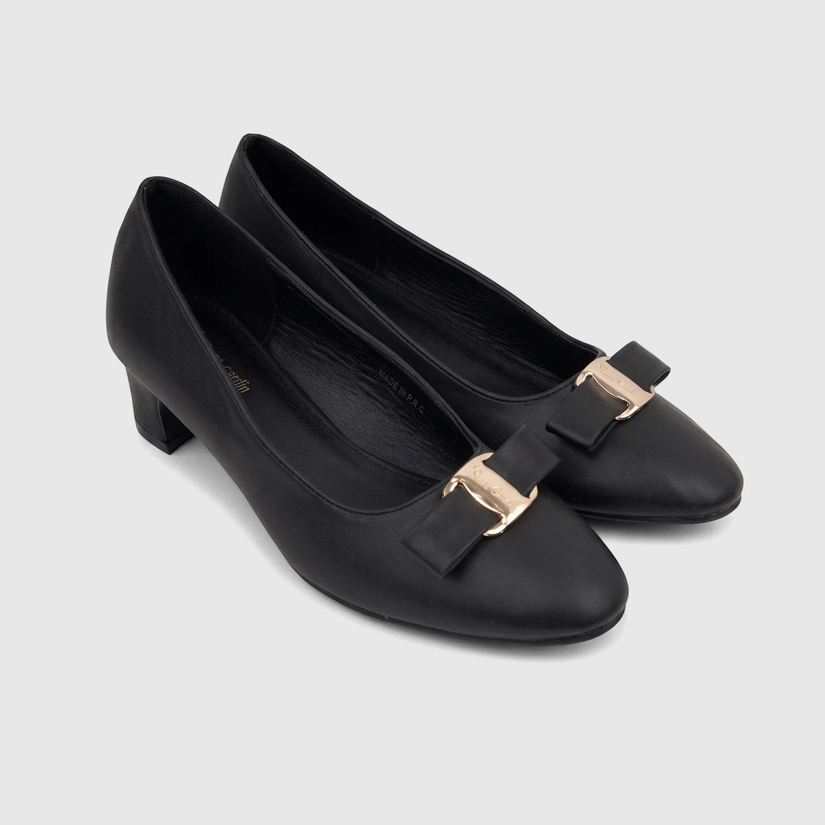 Black PC Ladies Dress Court shoes with block heels, leather upper, and gold buckle-bow detail, seen from an elevated angle.
