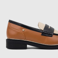 Side view of a PC Ladies Dress Loafer PCL10996 in tan and black leather, featuring a gold-tone logo and black sole.