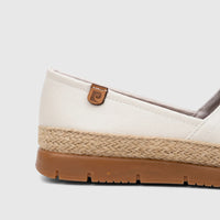 Close-up side view of a white casual espadrille loafer featuring a textured upper, braided jute trim, and a brown rubber