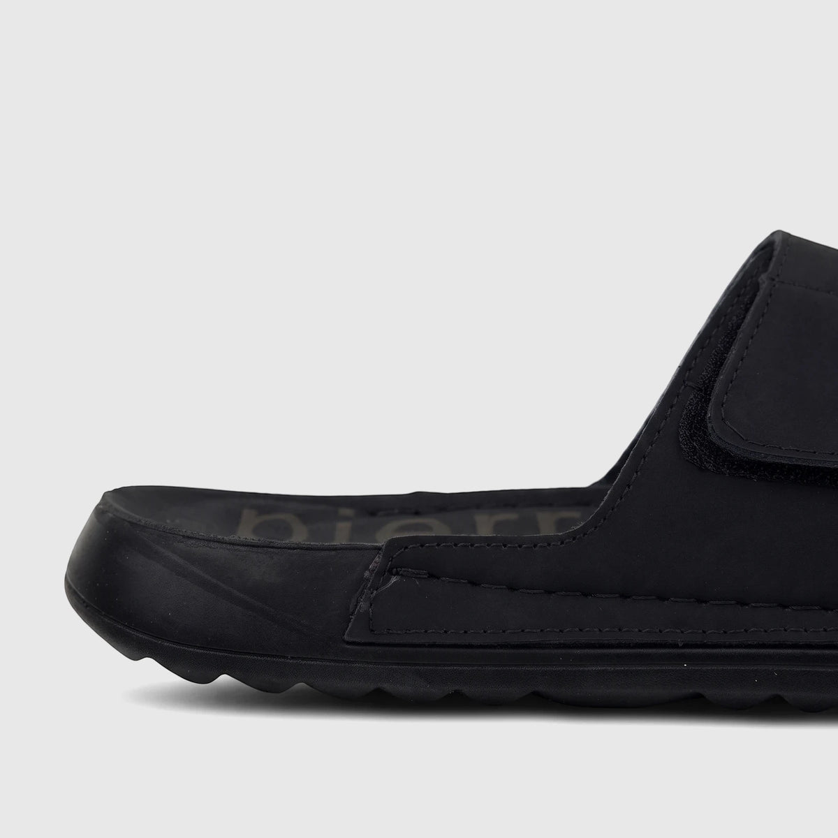Close-up of a black PC Men's Casual/Comfort Sandal PCM00815 PM7 with a textured sole and velcro strap, viewed from the side.