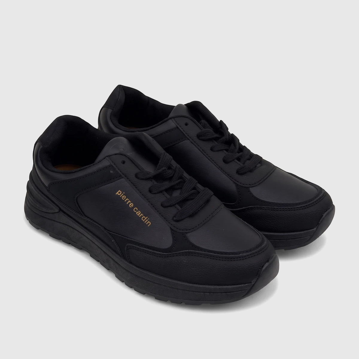 Two black Pierre Cardin ladies' casual sneakers, featuring gold branding, black laces, and textured soles, displayed in a