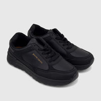 Two black Pierre Cardin ladies' casual sneakers, featuring gold branding, black laces, and textured soles, displayed in a