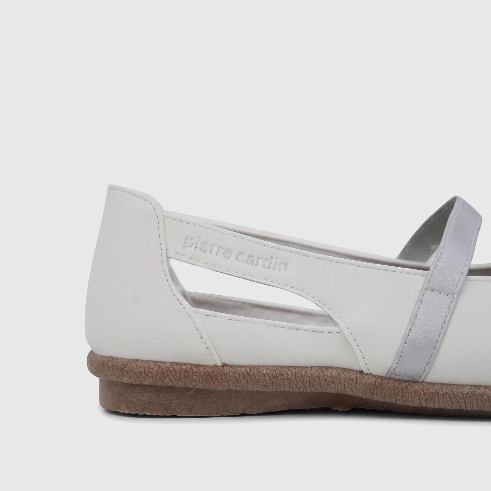 Close-up of a white Pierre Cardin ladies' casual pump with a silver strap and a textured brown sole, viewed from the side.