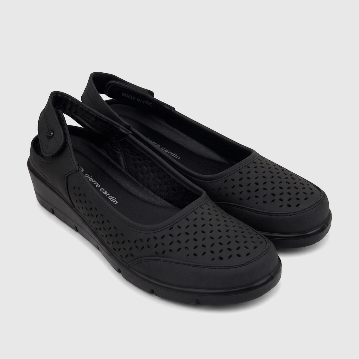 A pair of black Pierre Cardin ladies' casual wedge shoes with perforated uppers and slingback straps, shown from an elevated