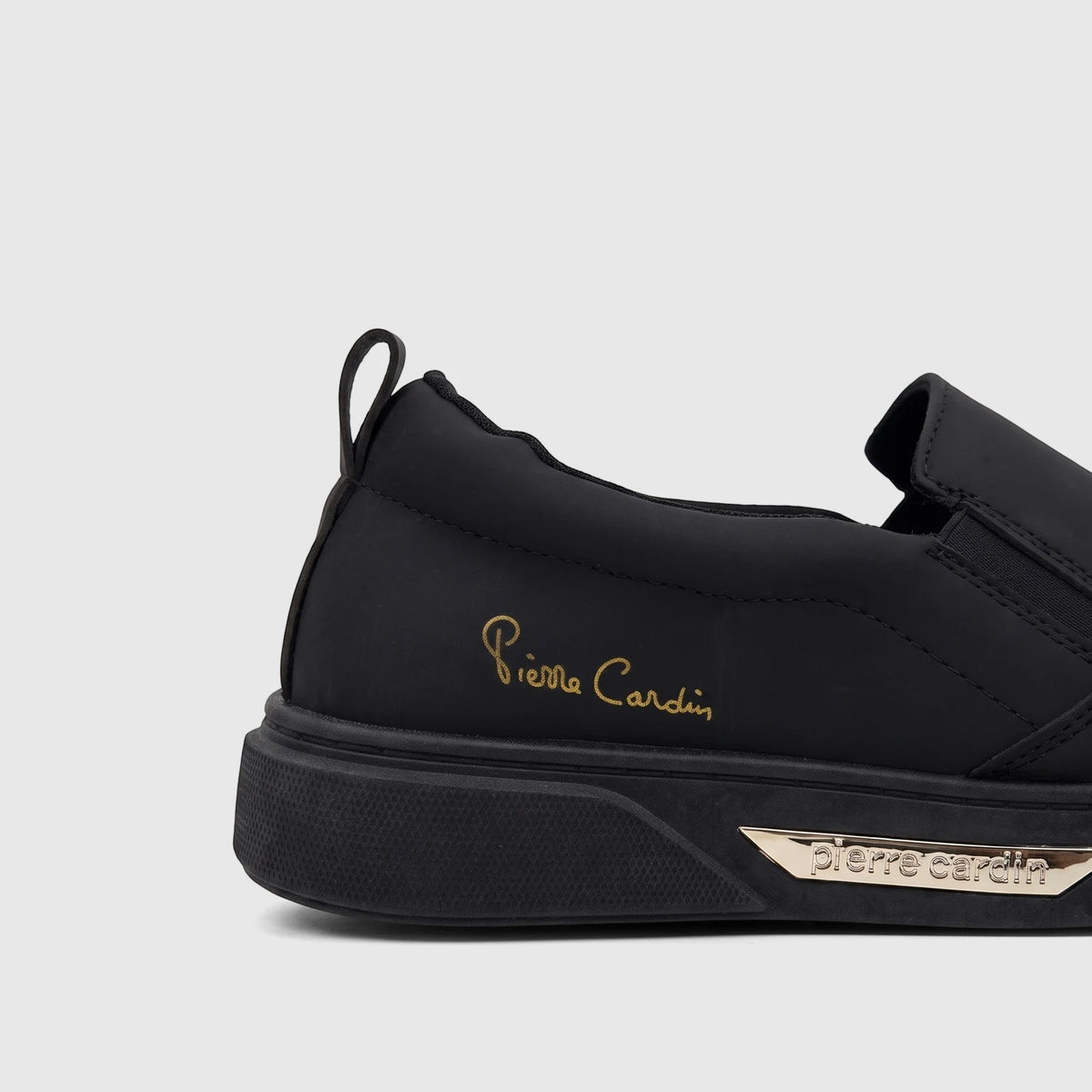Black Pierre Cardin women's casual slip-on sneaker, featuring a gold script logo on the side and a metallic plate with