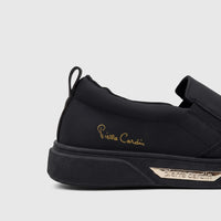 Black Pierre Cardin women's casual slip-on sneaker, featuring a gold script logo on the side and a metallic plate with
