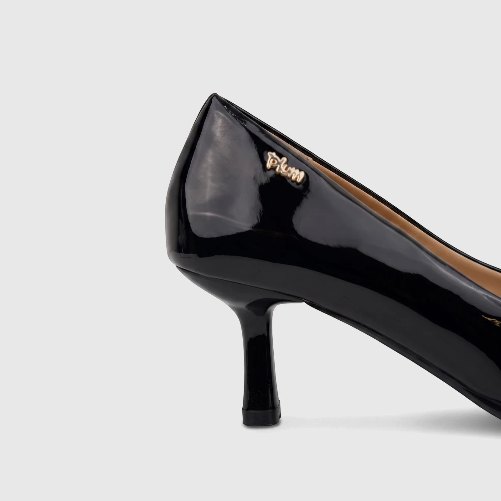 Close-up of a glossy black patent leather Plum dress court heel shoe with a kitten heel, showcasing its sleek design.