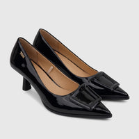Two shiny black patent leather women's high heel court shoes with prominent square buckles on a white surface.