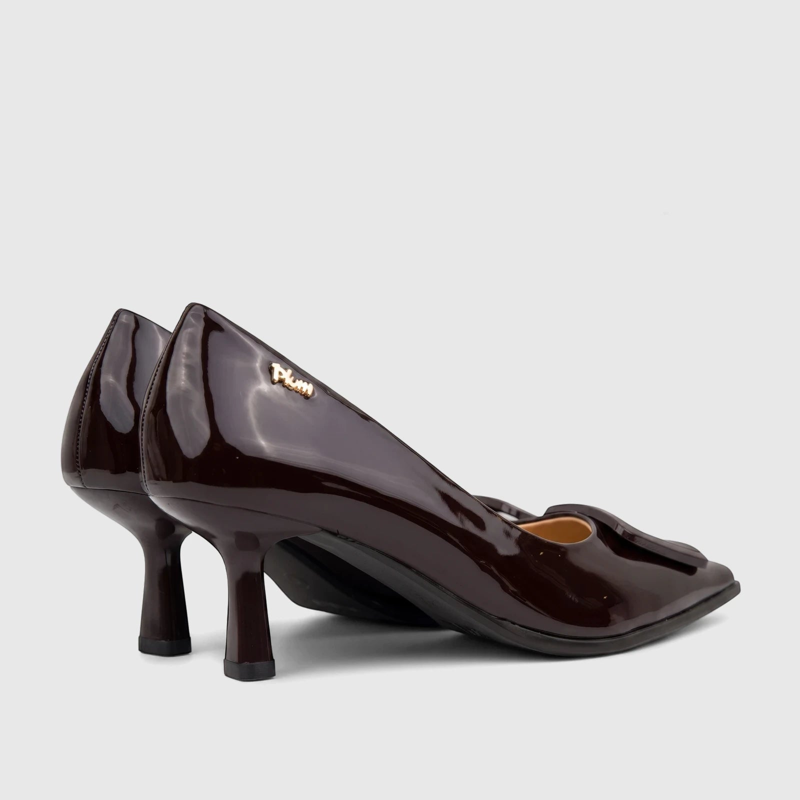 A pair of dark brown patent leather Plum Ladies Dress Court Cameron shoes with pointed toes and stiletto heels, viewed from