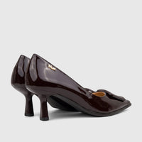 A pair of dark brown patent leather Plum Ladies Dress Court Cameron shoes with pointed toes and stiletto heels, viewed from