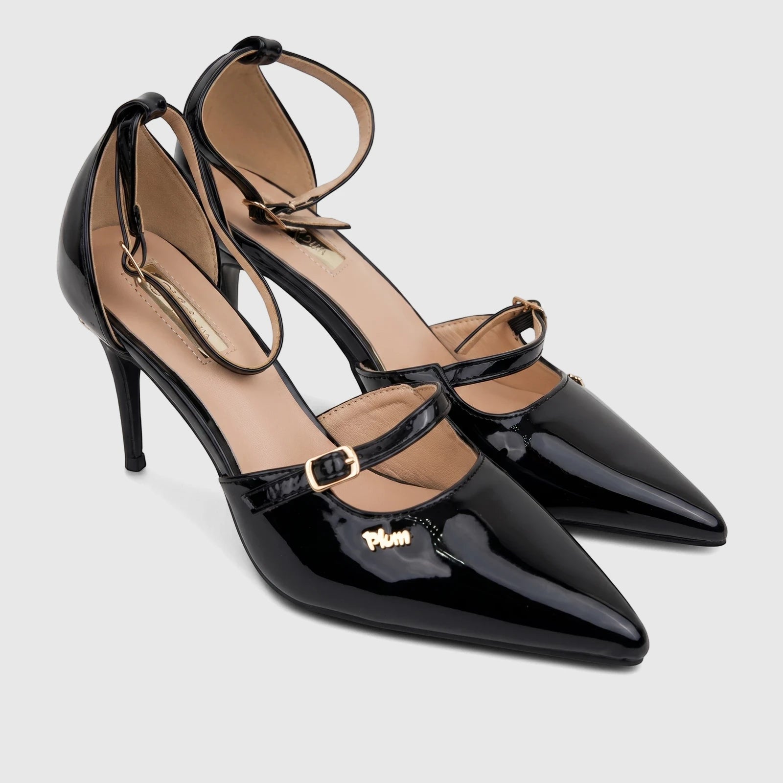 Black patent leather Plum Ladies Dress Court Raven PL095622 pointed-toe high heels with elegant ankle straps on a white