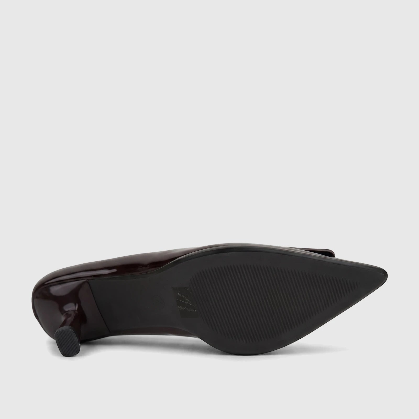 Plum patent leather ladies' dress court shoe, showing the textured sole and low block heel from a side view.