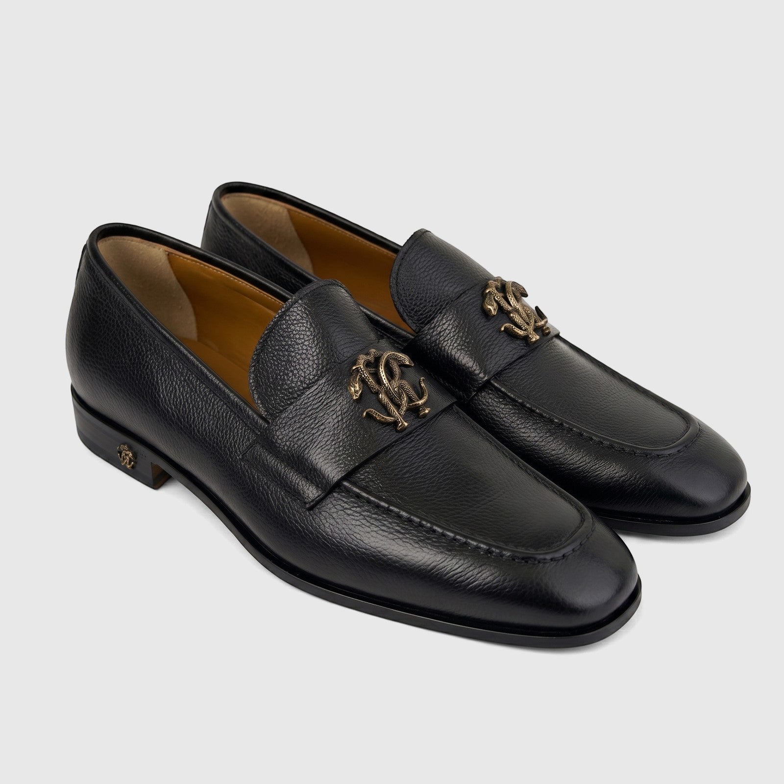Pair of Roberto Cavalli Men's Black Leather Dress Slip-On Loafers with gold-tone snake logo on a white background.