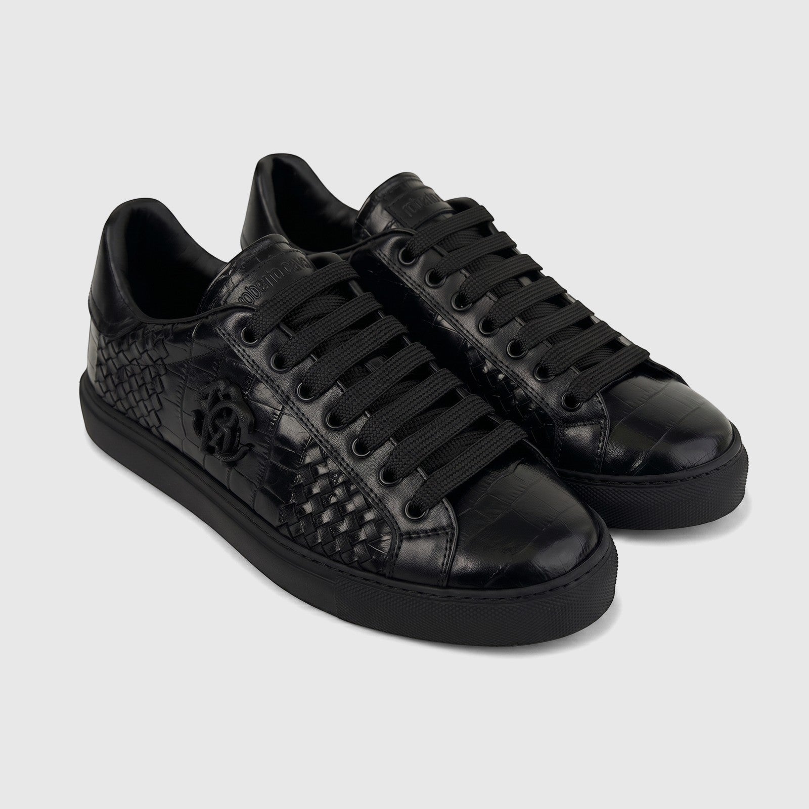 Pair of black Roberto Cavalli men's low-top leather sneakers with woven and crocodile-embossed textures.