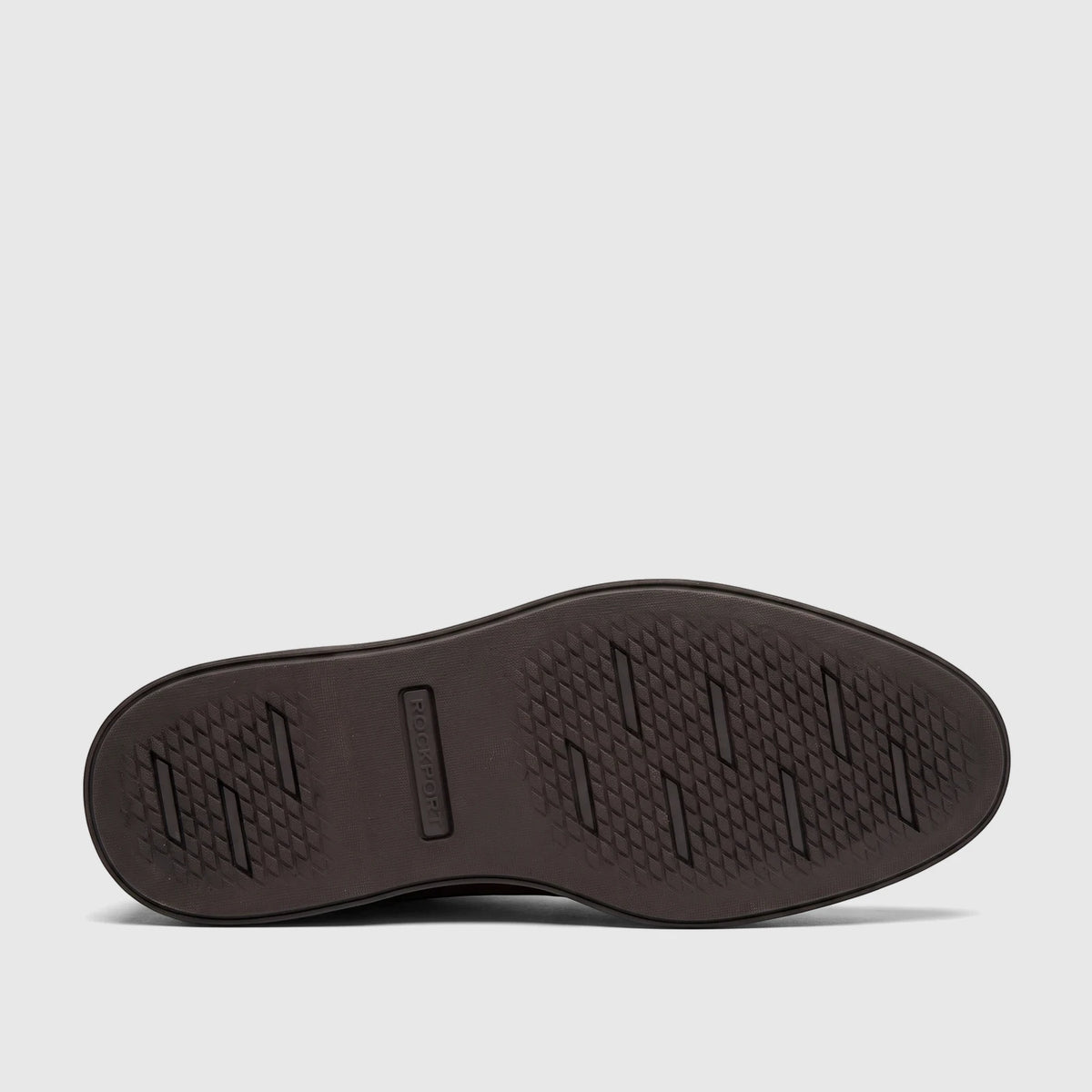 Bottom view of a Rockport men's dress comfort shoe sole in dark brown with a diamond pattern grip and embossed logo.