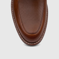 Close-up top view of a Rockport Men's Leonard dress/comfort shoe in British Tan pebbled leather with white stitching.