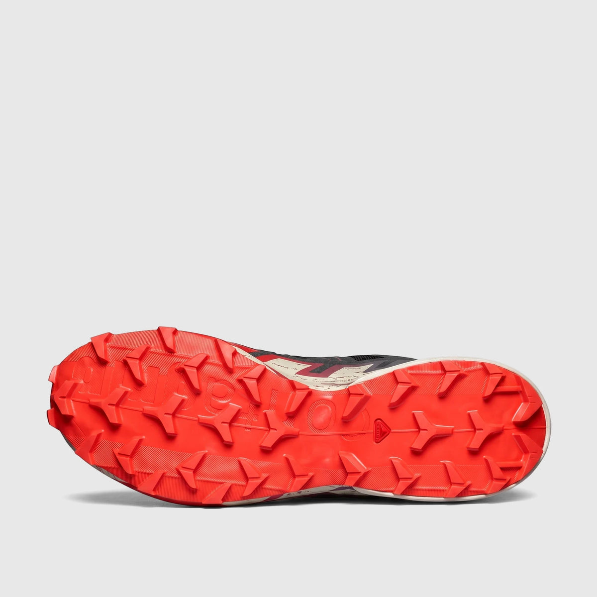 Salomon Men's Speedcross 6 sneaker sole view. Features fiery red, black, and almond milk colors with aggressive lugs for