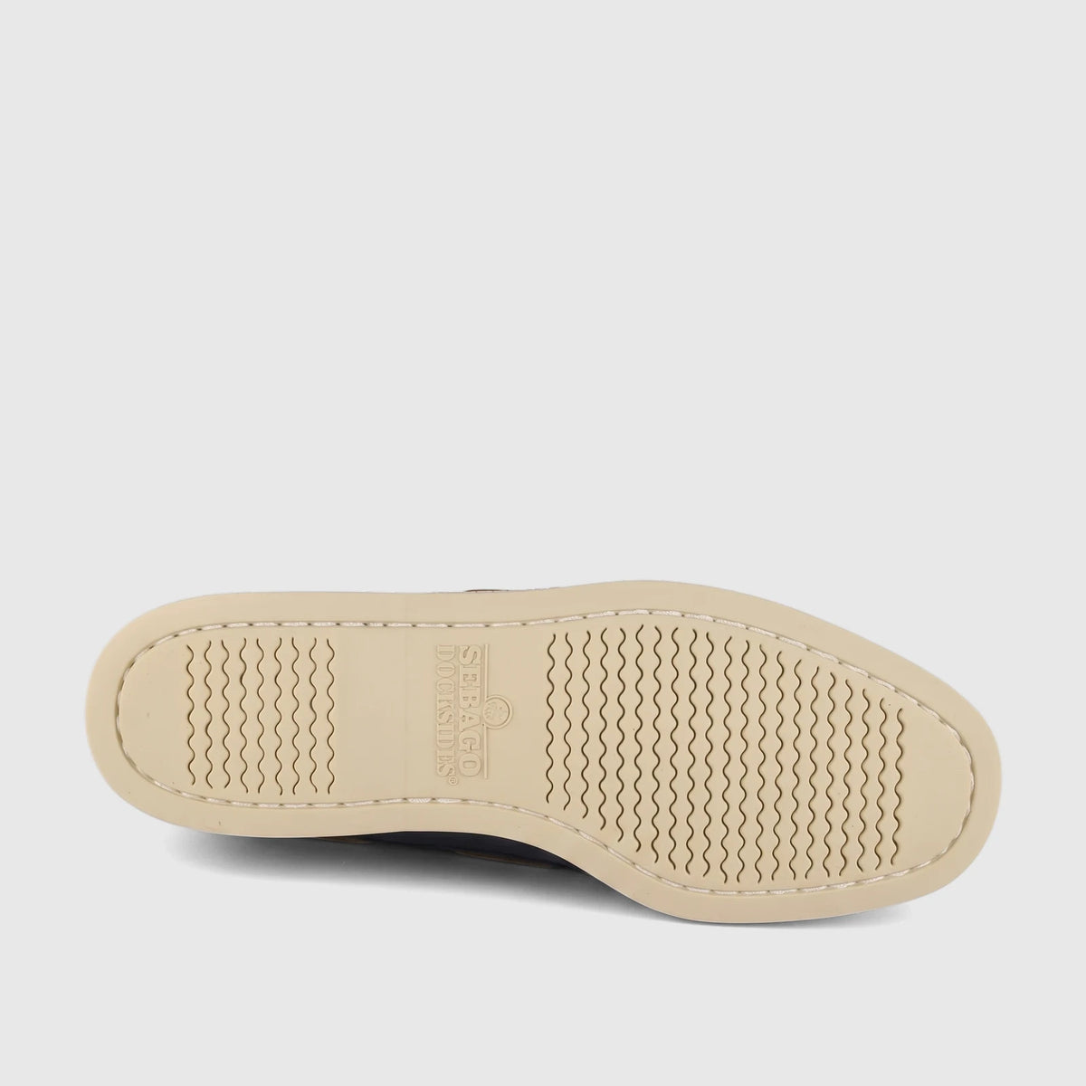 Sole of a Sebago Men's Docksides Portland Nubuck boat shoe, showing cream outsole with wavy traction and the Sebago