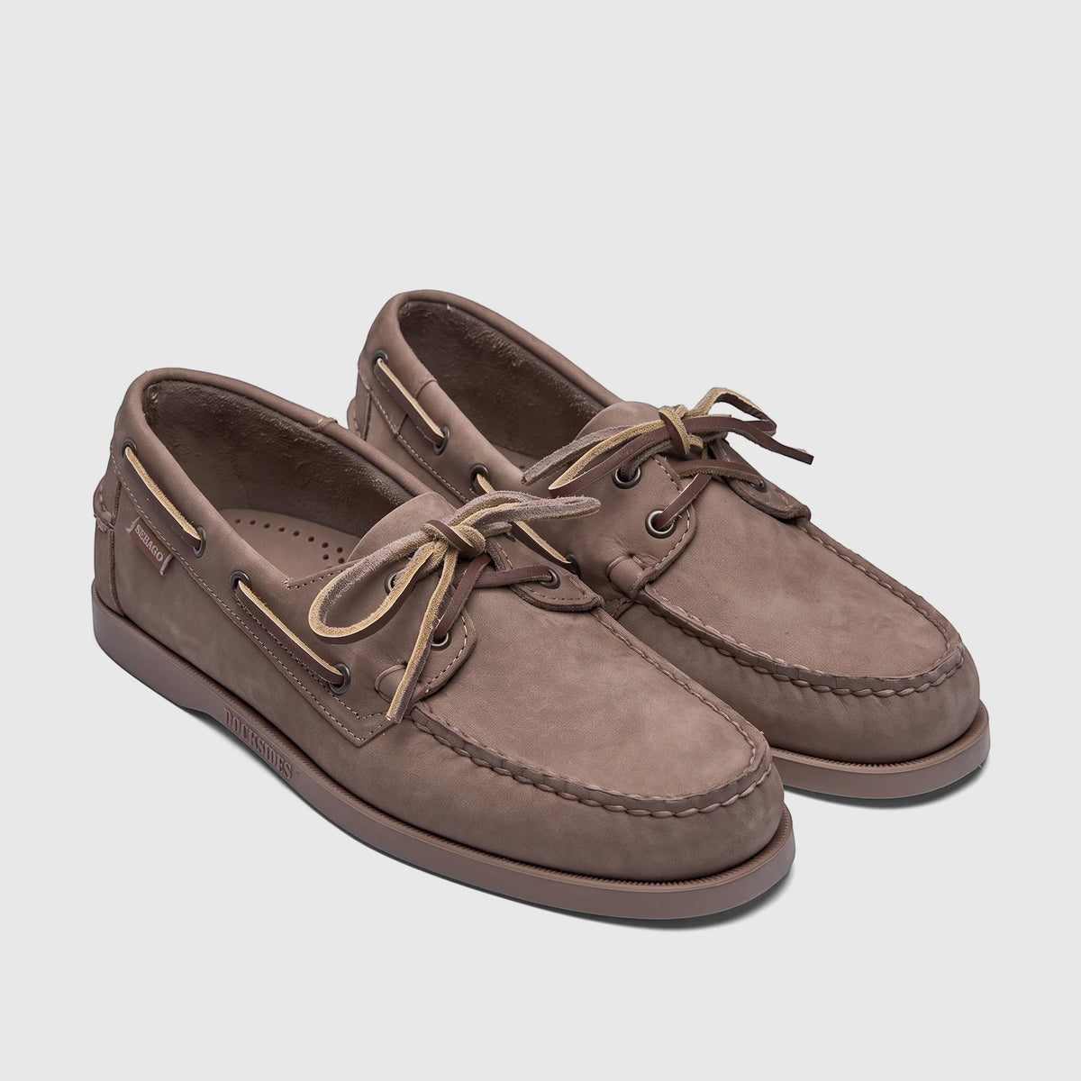 A pair of men's Sebago Docksides Portland boat shoes in brown taupe nubuck leather with light laces, viewed from an angle.