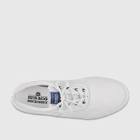 Top-down view of a white canvas Sebago Docksides men's sneaker, featuring white laces, black eyelets, and brand logos on the