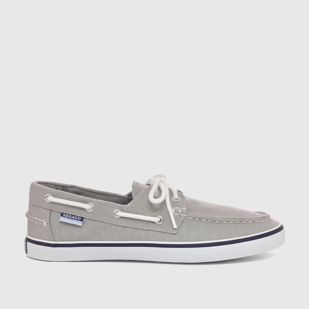 A single grey canvas Sebago Unisex Boat Shoe with white laces, a white sole, and a navy stripe, shown in a side profile view.