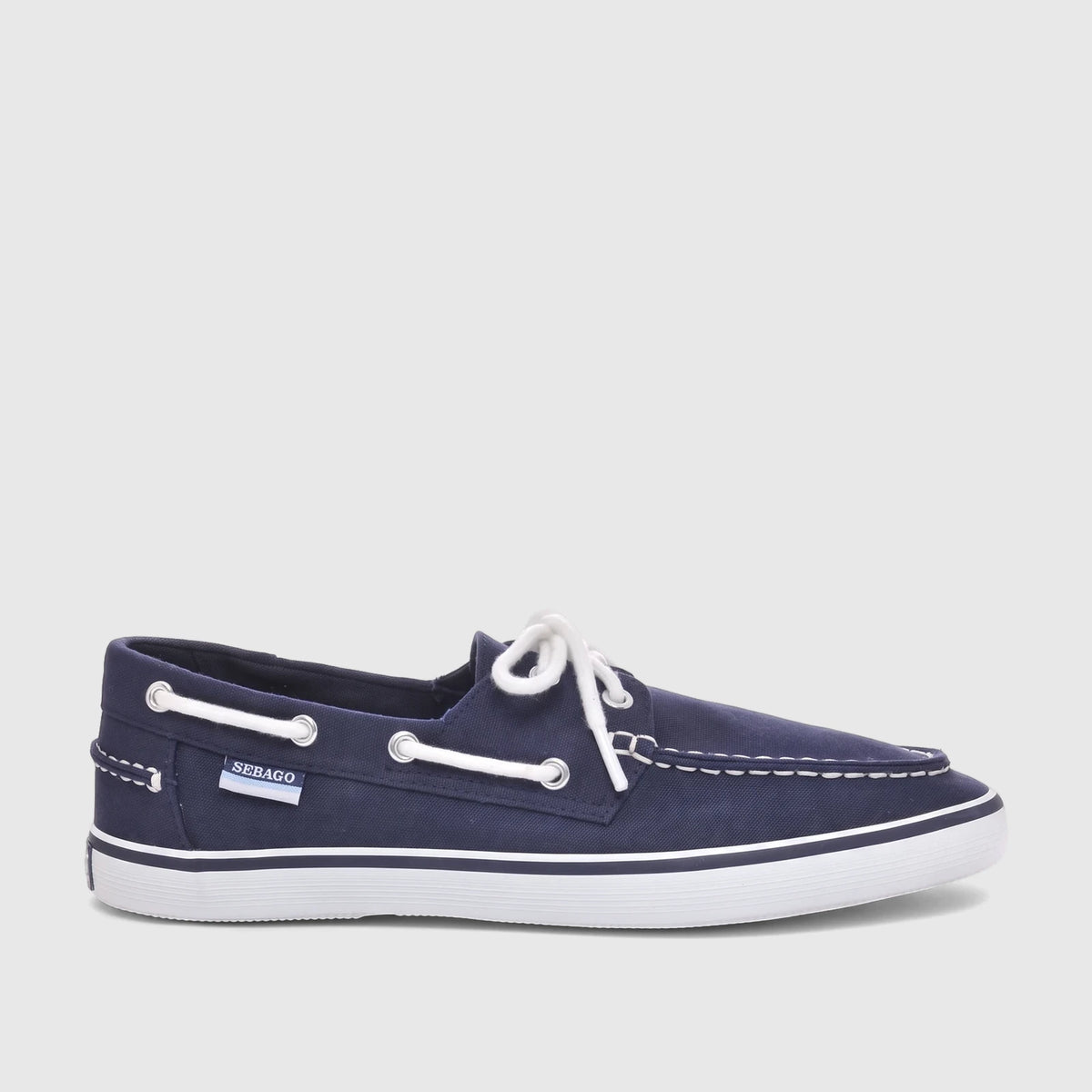Sebago Unisex Boat Shoe Pascal in navy blue canvas with white laces, a white sole, and a side logo. Side view.