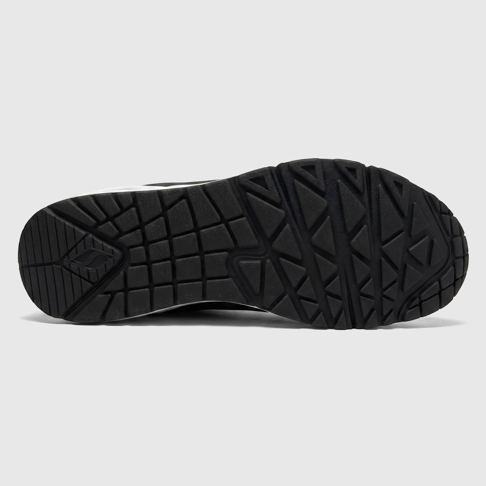 Bottom view of a black Skechers Uno Comfort Sneaker, highlighting the durable rubber outsole with geometric tread patterns.