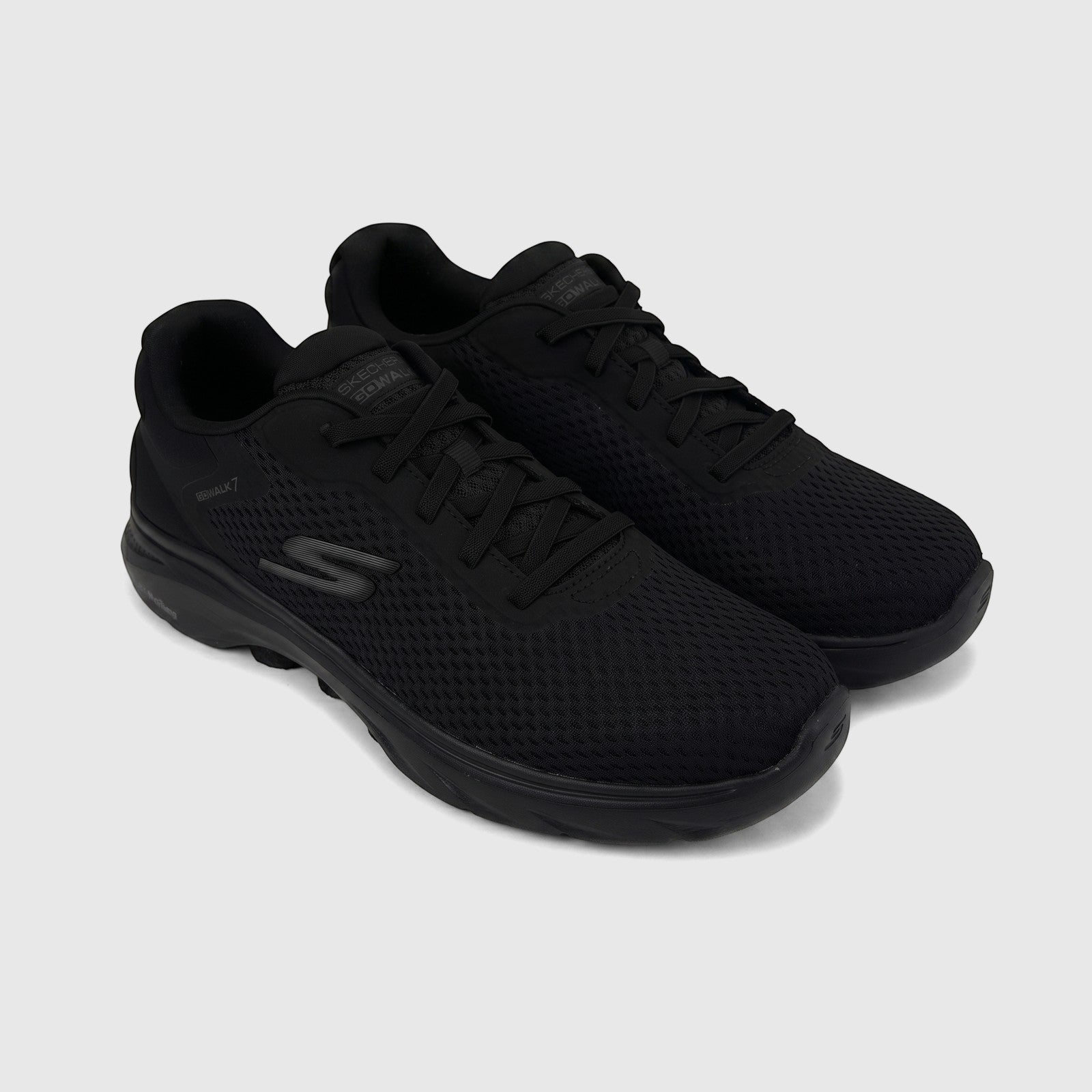 A pair of black Skechers Men's Go Walk 7 comfort sneakers with mesh uppers, shown angled on a white surface.