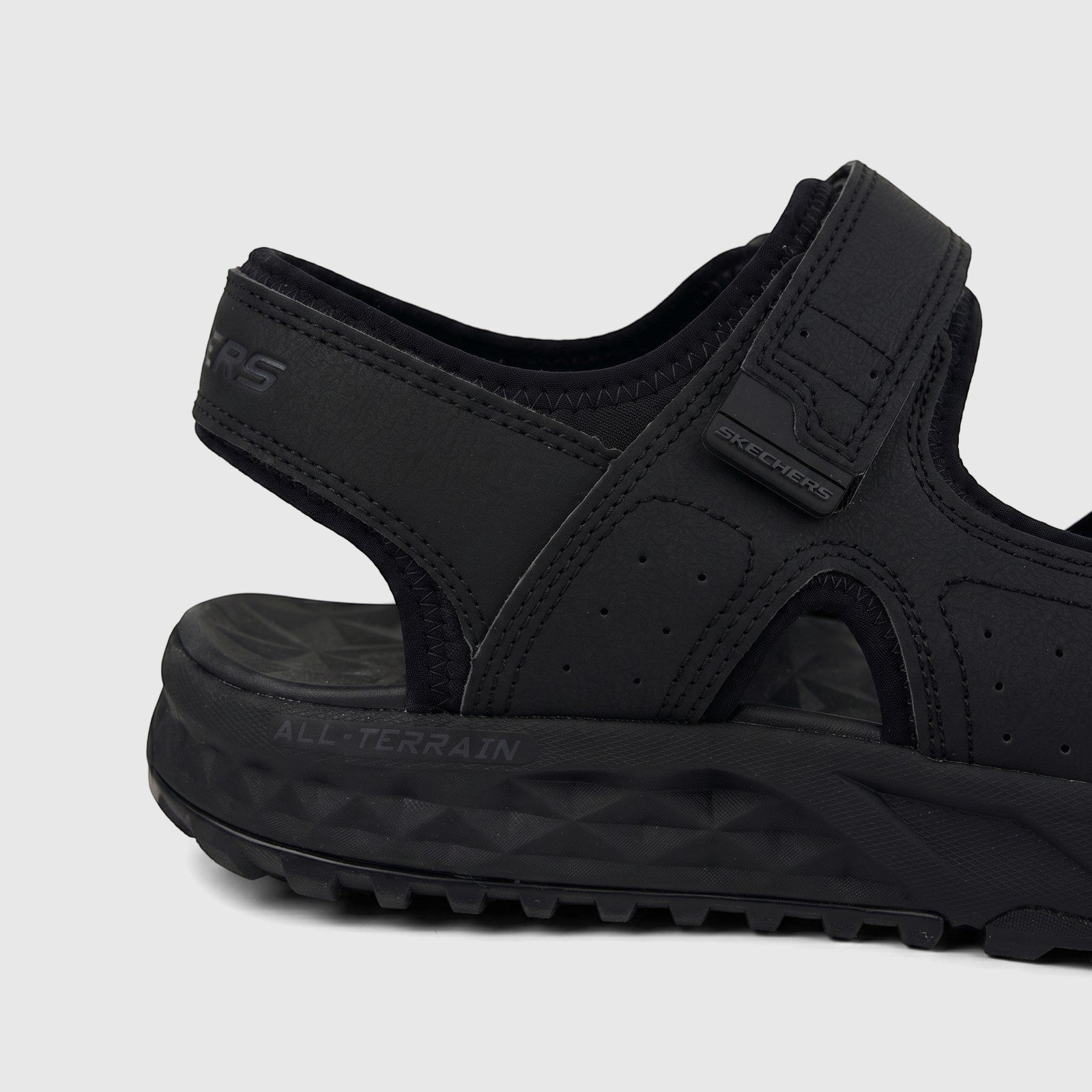 Close-up side view of a black Skechers Men's Adventure Sandal Escape Plain Trail with 'SKECHERS' logo and 'ALL-TERRAIN'