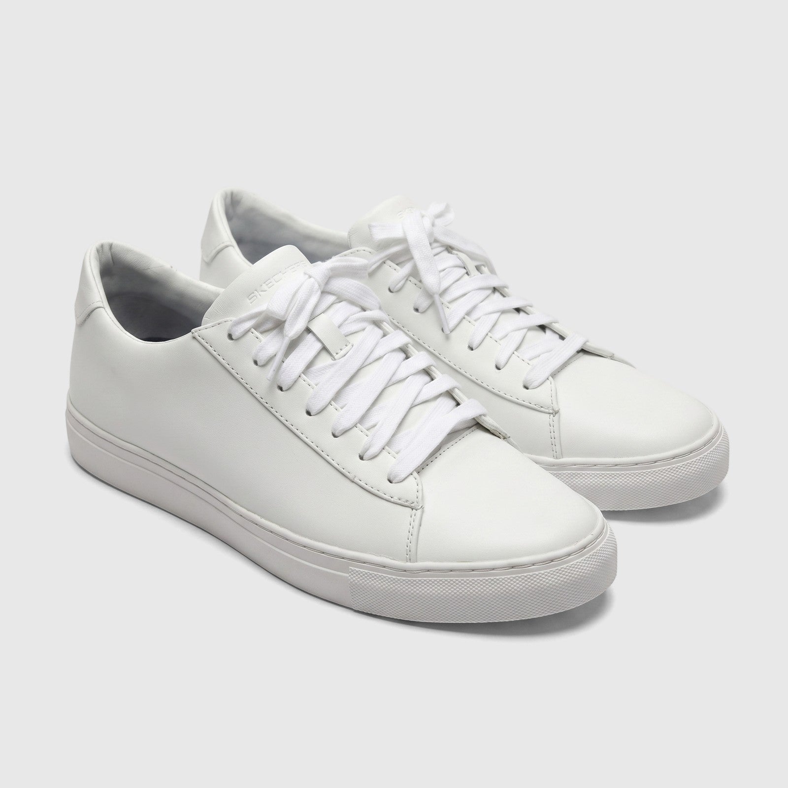 A pair of Skechers Men's Comfort Arch Fit Legend 237604 white sneakers with smooth uppers and white laces, presented in a