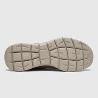 Underside view of a taupe Skechers Men's Comfort Slip Ins sneaker sole, showcasing the textured, non-slip tread design.