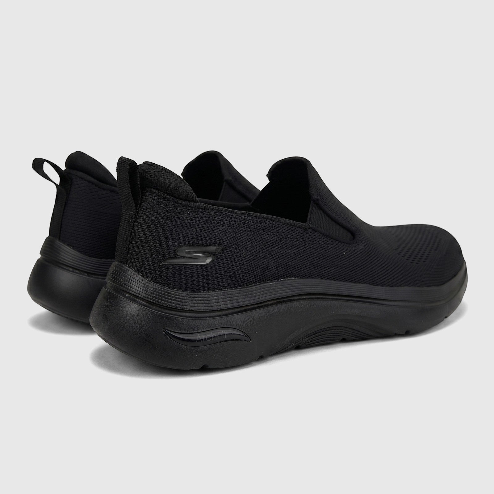 Pair of black Skechers Men's Comfort Slip On Arch Fit 2.0 sneakers shown from a rear three-quarter view on a white