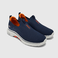 Skechers Men's Go Walk 7 slip-on sneakers in navy blue with orange accents, shown from an angled view.