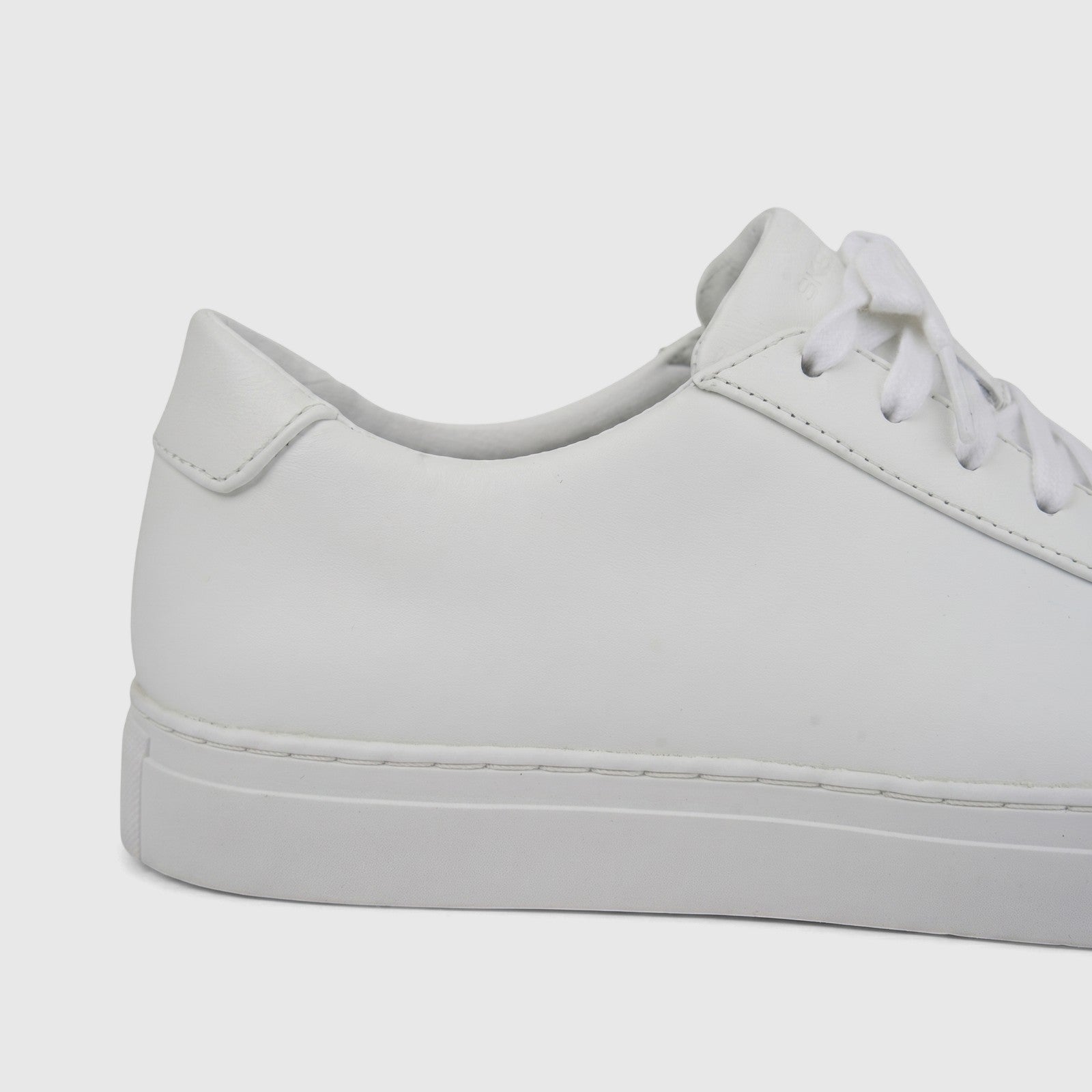 A close-up side view of a white leather Skechers Men's Comfort Sneaker Arch Fit Legend with white laces.