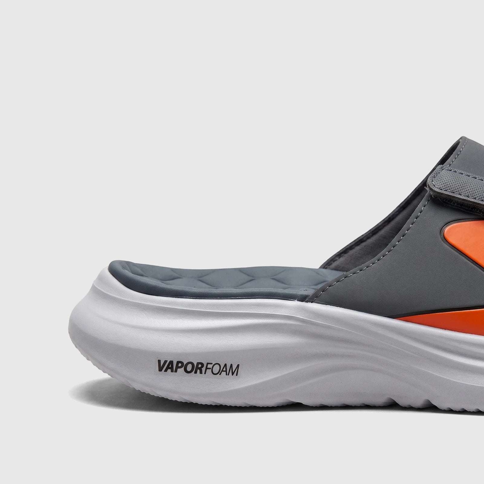 Close-up side view of a Skechers Men's Comfort Vapor Foam Sandal in grey and orange, featuring a white Vapor Foam sole.