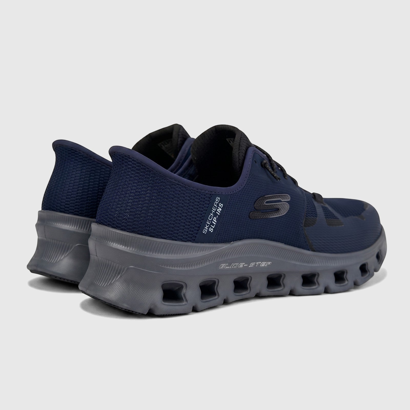 Skechers Men's Glide-Step Pro comfort sneakers in navy and charcoal, rear quarter view, on a studio backdrop.