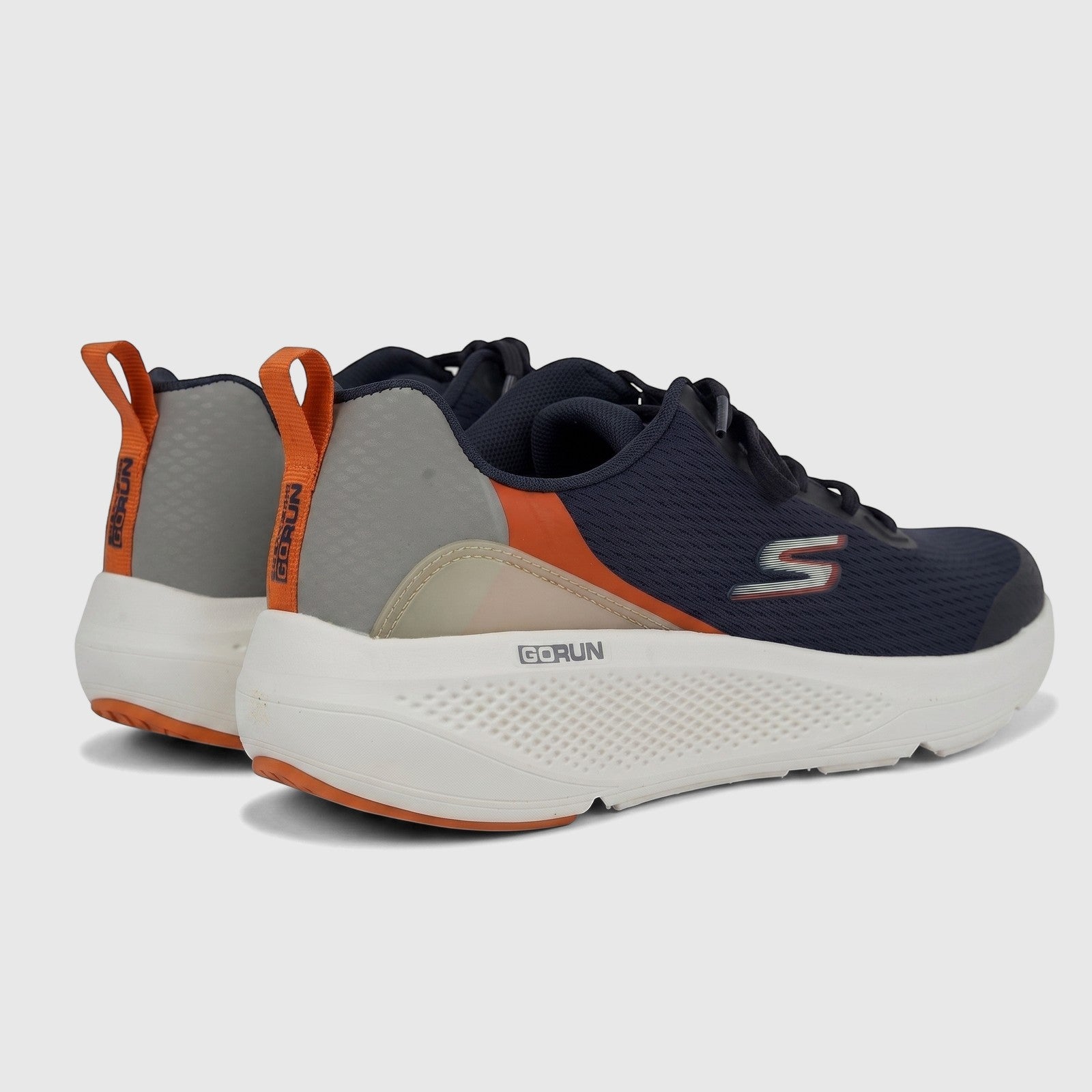 Skechers Men's Go Run Elevate 220189 comfort sneakers in navy and orange, shown from a rear-side view on a studio floor.