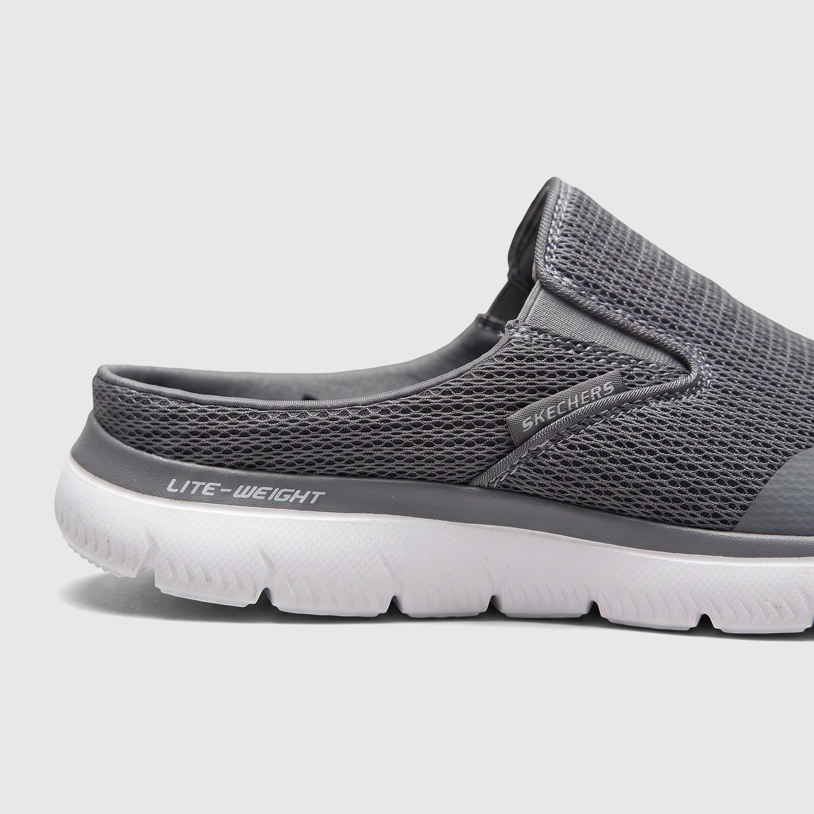 Side view of a grey Skechers Men's Comfort Open Back Slip On Summits Vindicator shoe with mesh upper and white lightweight