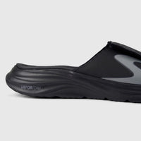 Close-up of a black Skechers Men's Vapor Foam slide sandal, showcasing its contoured midsole and adjustable strap.