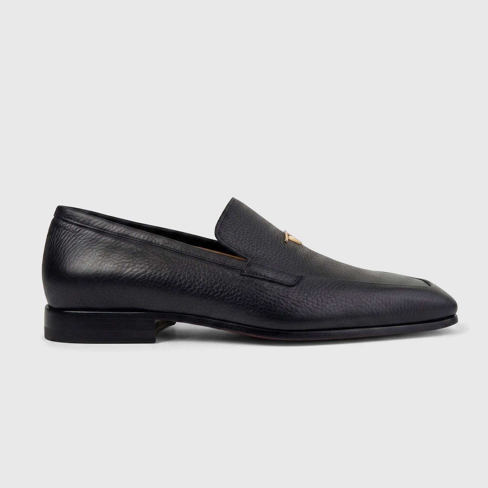Valentino Men's Black Grained Leather Dress Slip-On Loafer shoe with gold-tone hardware, side view.