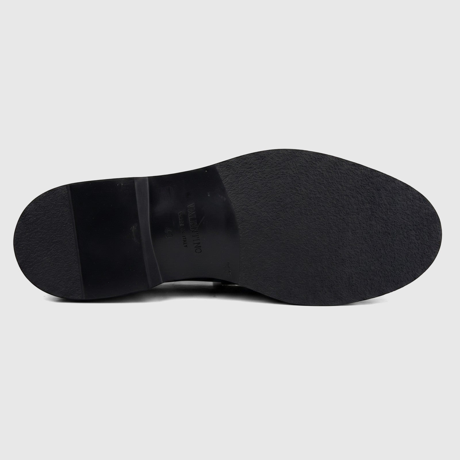 Valentino men's black leather slip-on shoe featuring a chunky sole, shown from the bottom revealing the textured outsole.