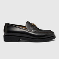 Black leather Valentino men's slip-on loafer with a chunky sole and gold-tone V-logo from a side view.