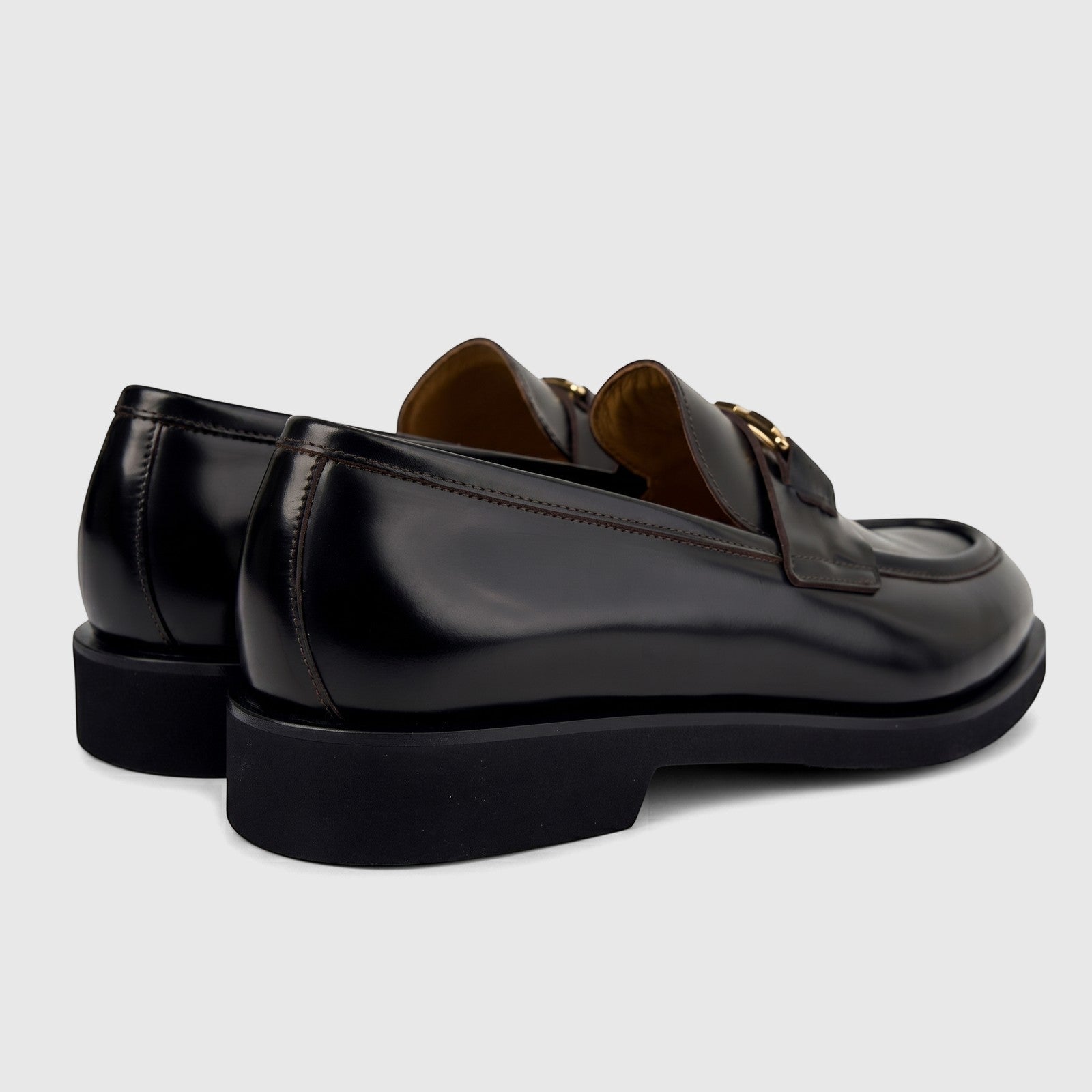 Valentino Men's Black Leather Chunky Sole Slip-On Shoes, featuring gold buckles and visible stitching, viewed from a