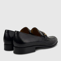 Valentino Men's Black Leather Dress Slip On shoes, detailed side and rear view, featuring a polished gold buckle on the