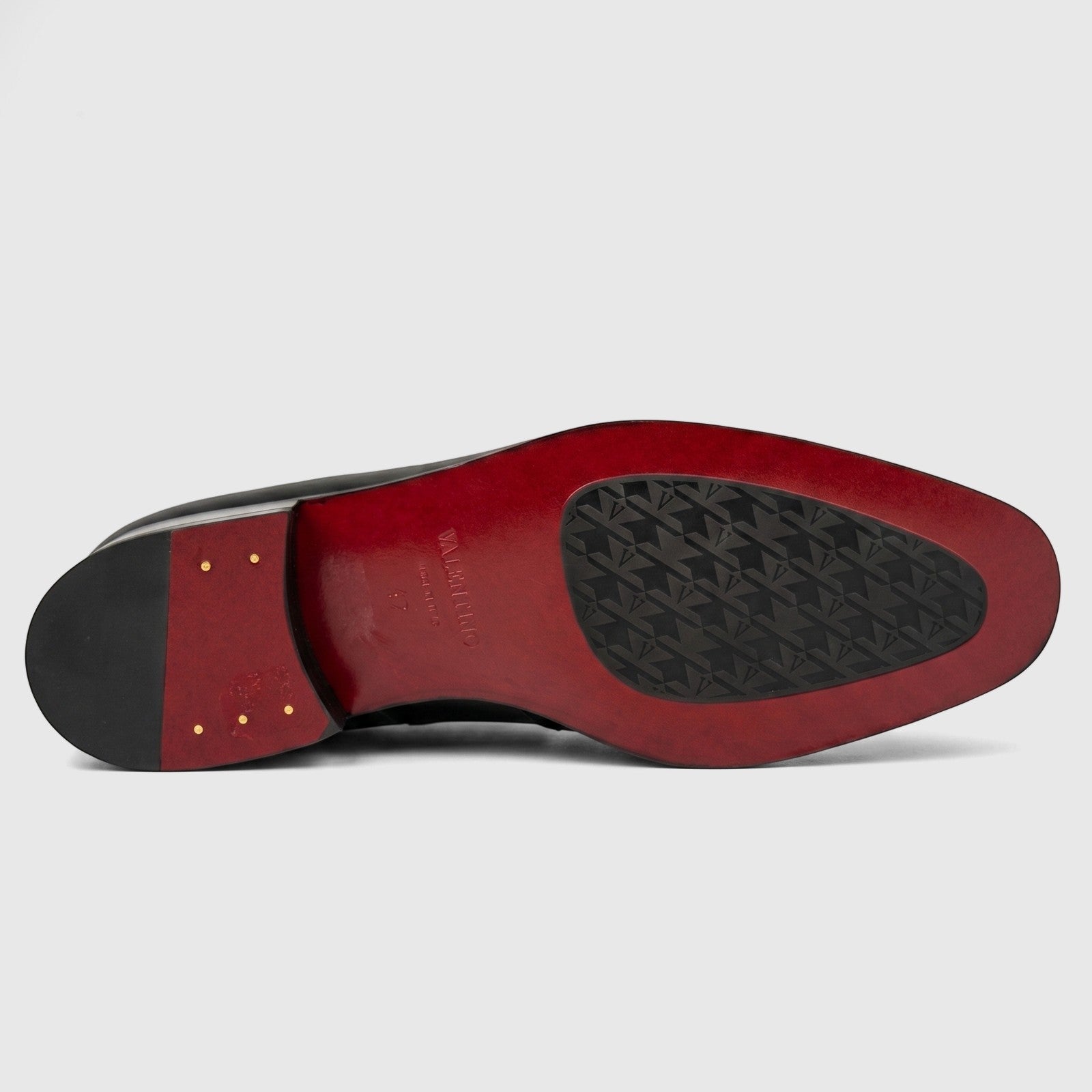Valentino Men's Leather Dress Slip On shoe, black with a distinctive red sole and patterned rubber insert, shown from the